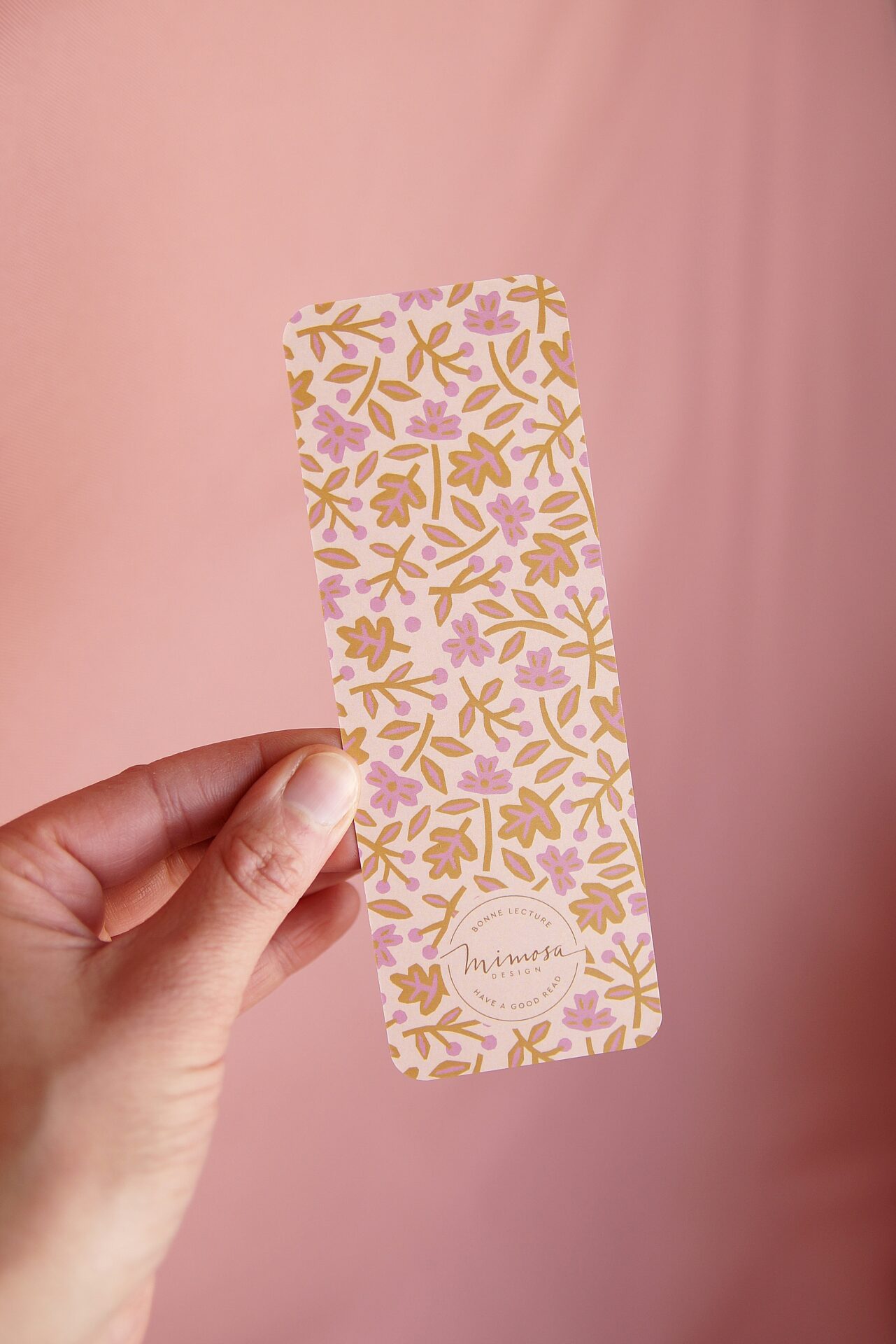 Signet Fleur de papier à motif floral composé de petites fleurs roses et de feuillage ocre sur fond pêche, création Mimosa Design.