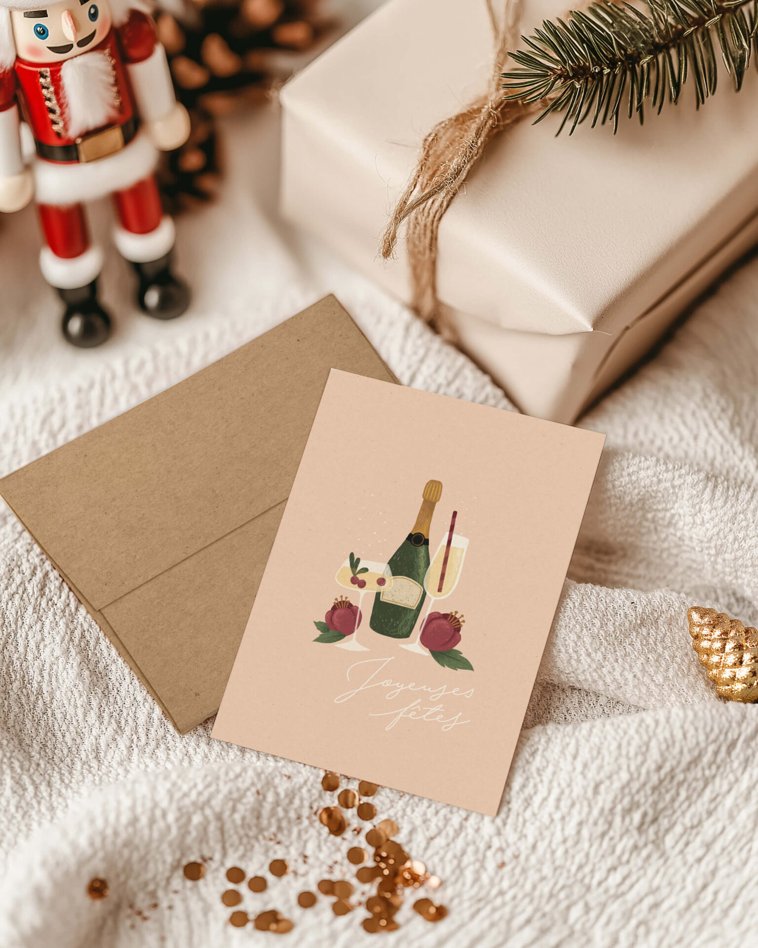 Carte de souhaits de Noël Bulles festives de Mimosa Design présentée avec son enveloppe kraft dans une ambiance chaleureuse des Fêtes, entourée d'un cadeau, d'un casse-noisette et de décorations de Noël.