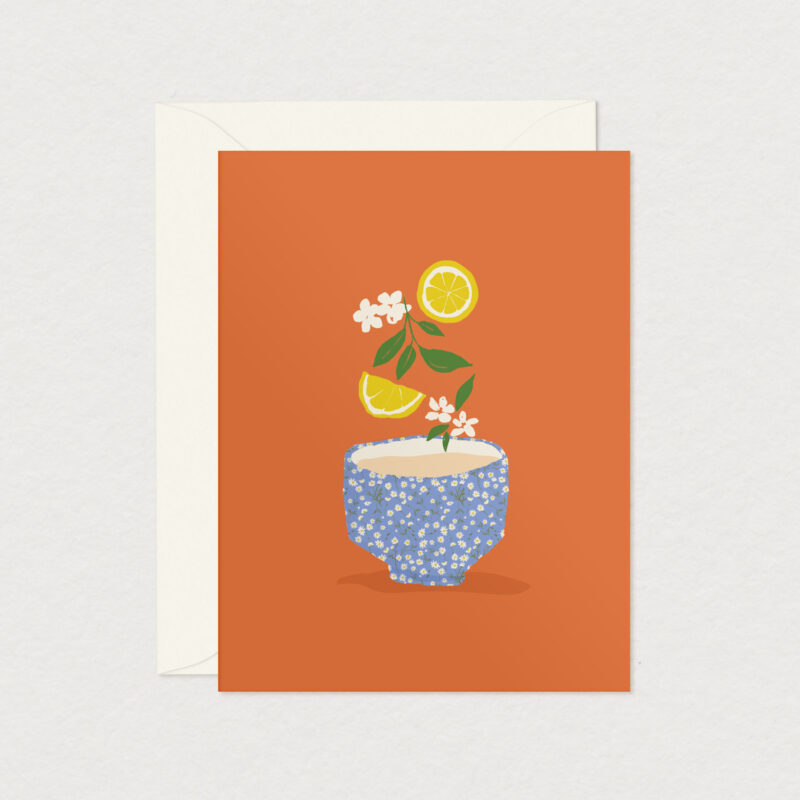 Carte de souhaits VitaliThé illustrée d’une tasse fleurie accompagnée de fleurs blanches et de tranches de citron